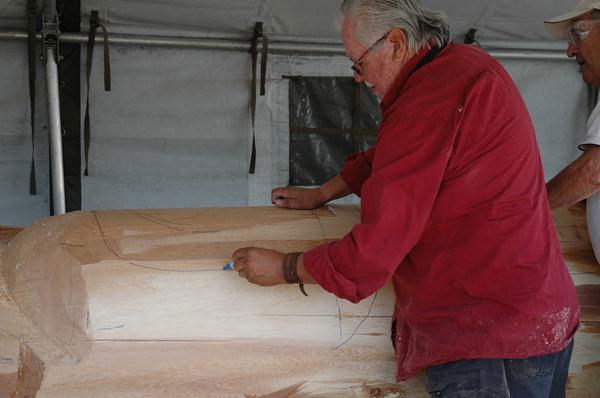 Tony Hunt draws carving lines on the large cedar log that will be <em>Hosaqami</em>.