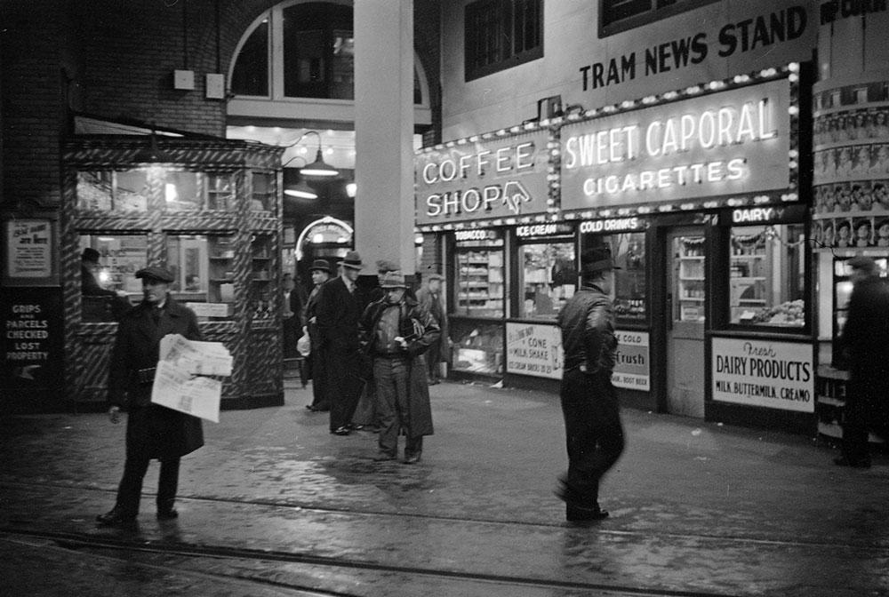 James Crookall <em>The tram news stand and coffee shop illuminated at night in the B.C. Electric building at 425 Carrall Street </em> 1937 Courtesy City of Vancouver Archives